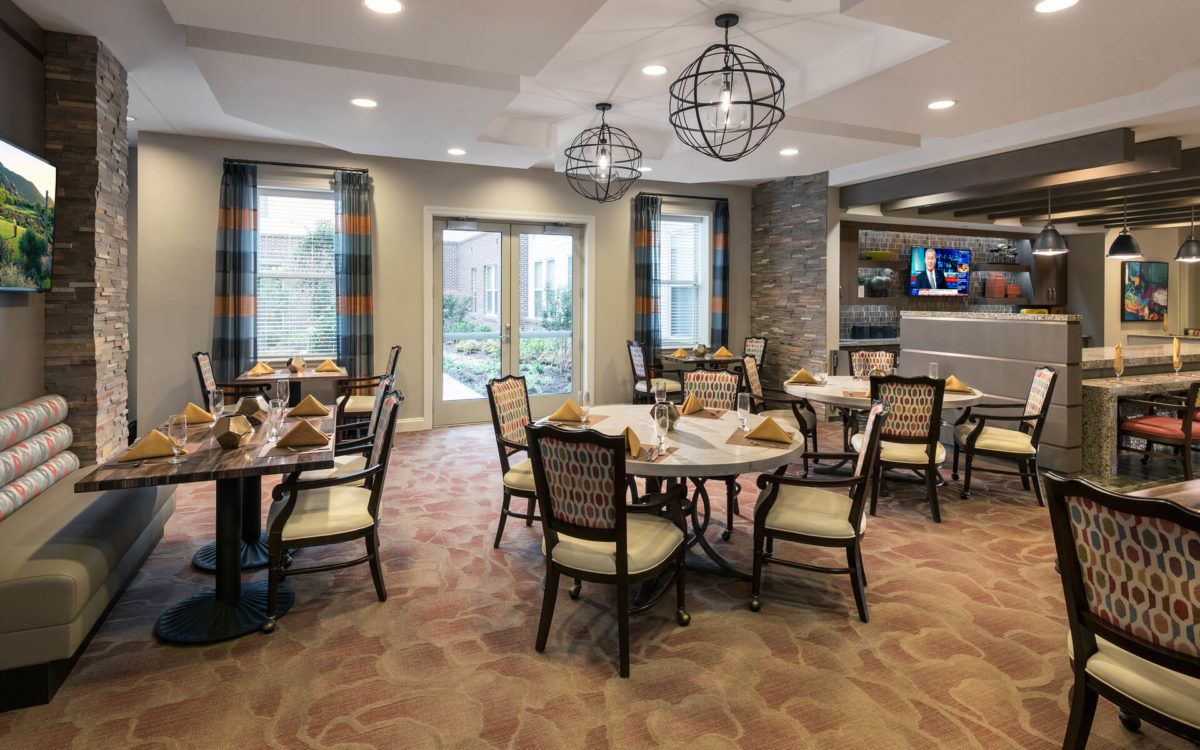 A stylish dining room with elegantly set tables, comfortable chairs, and modern lighting.