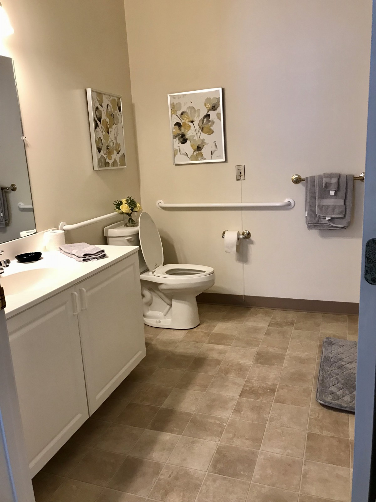 A clean and modern bathroom with a sink, toilet, and decorative elements.
