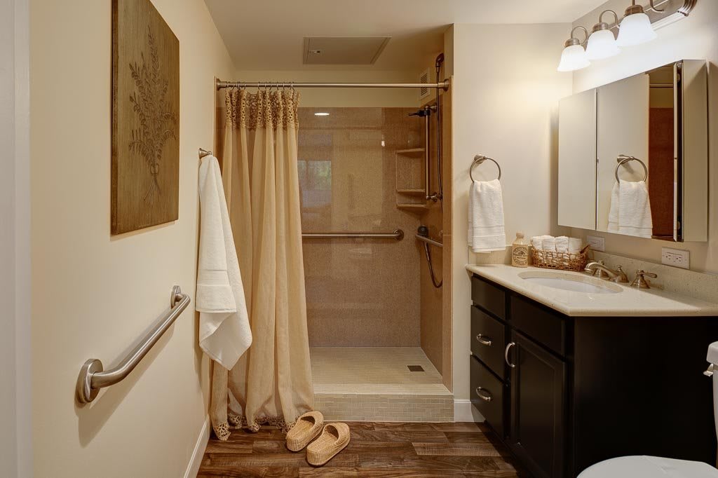 A well-organized bathroom with a shower area, vanity, and neatly hung towels.