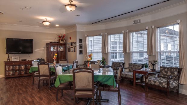 A cozy dining area with elegantly set tables and large windows.