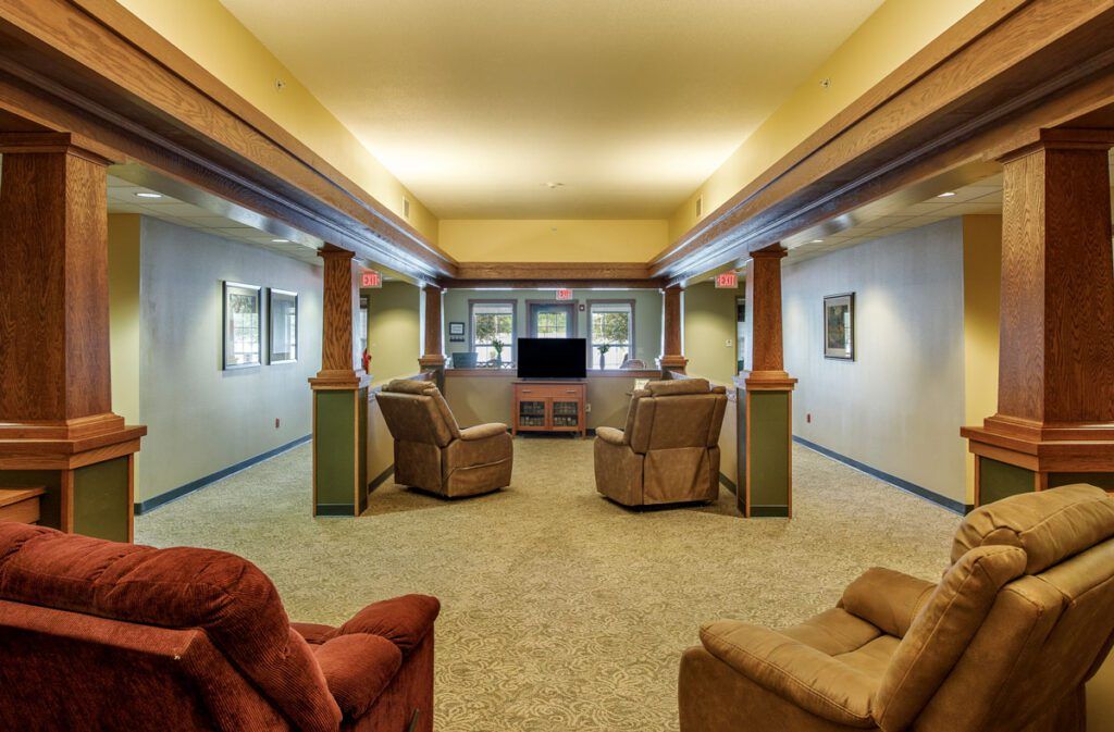 A furnished basement living area with comfortable seating and a television.
