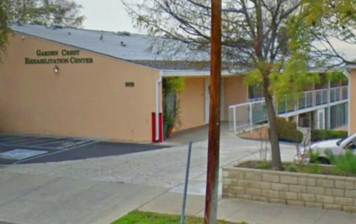 Exterior view of a building with an adjacent sidewalk and trees.