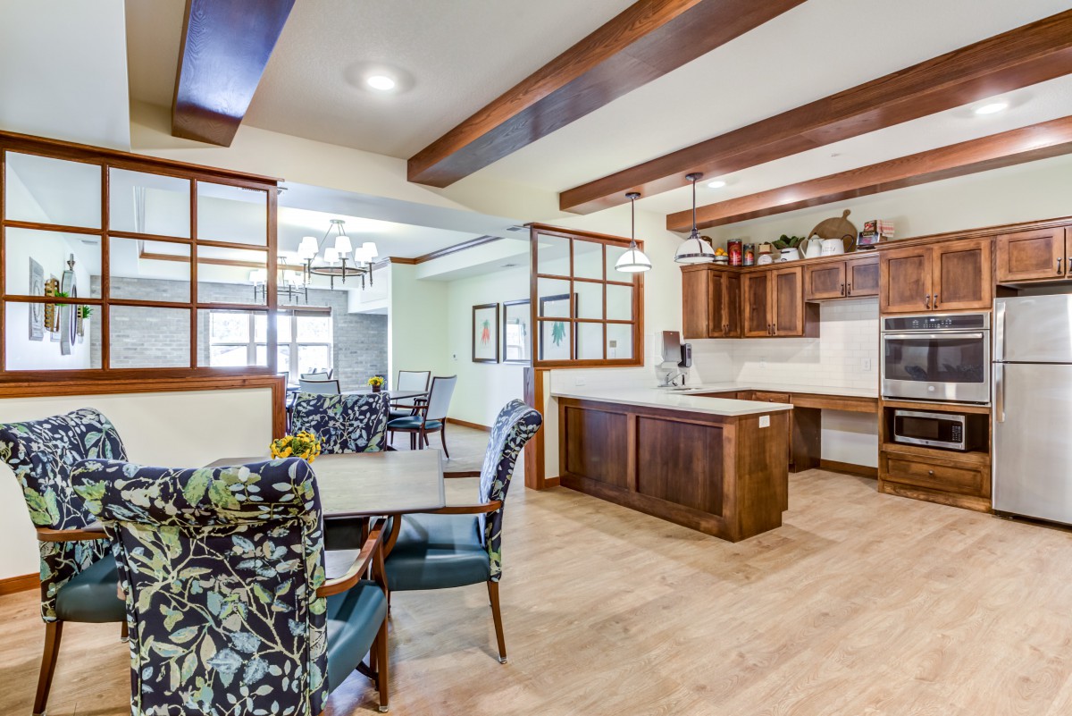 A modern open-concept kitchen and dining area featuring wooden beams and stylish furnishing.