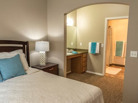 A cozy bedroom with a view of an adjoining bathroom.
