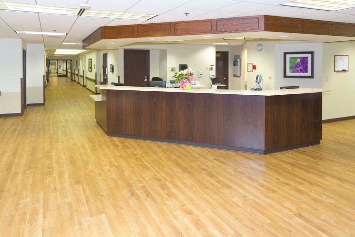 A hospital reception area with a central desk and adjacent hallway.