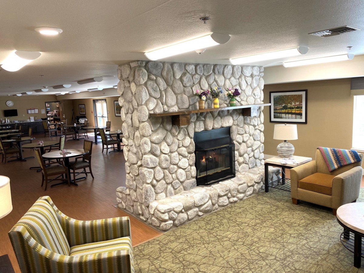 A cozy living room with a stone fireplace and comfortable seating.