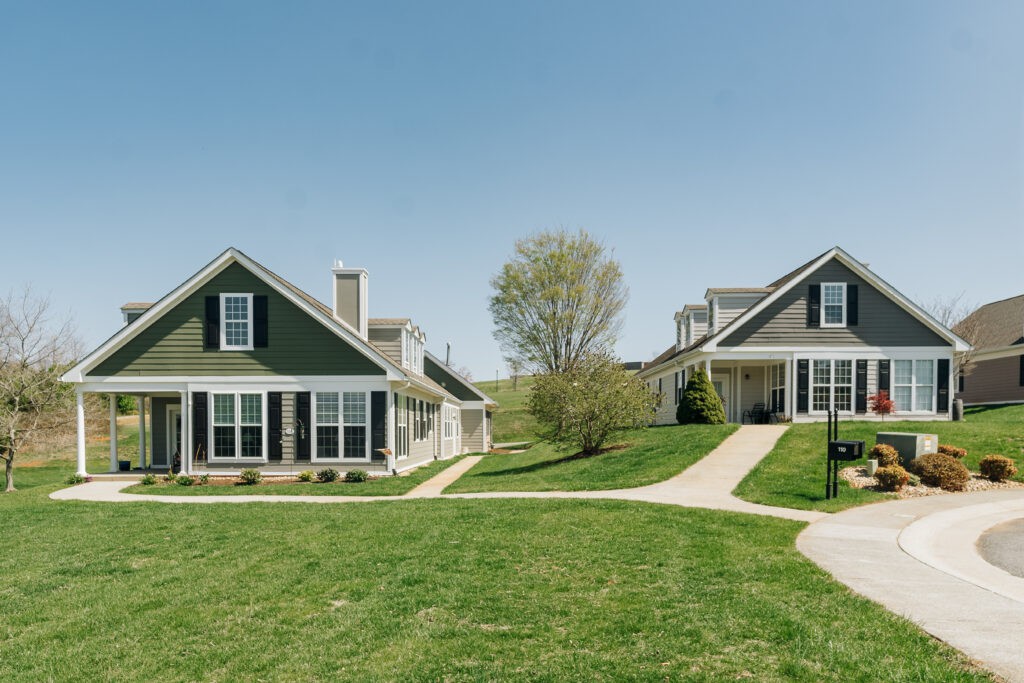 Two suburban houses with driveways and a well-maintained lawn.