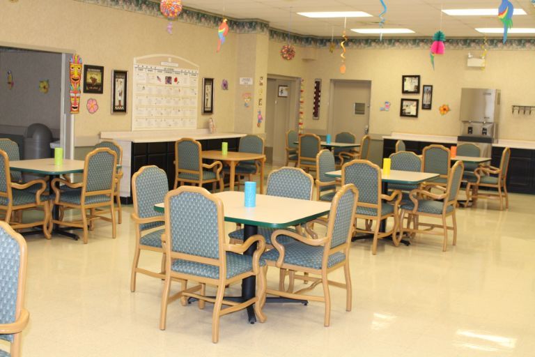 An empty dining room with several tables and chairs arranged neatly.