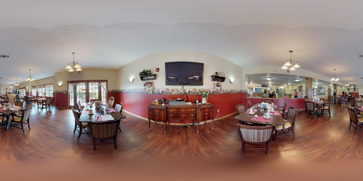 A cozy dining room with wood flooring and classic furniture, featuring elegant decor and artwork.