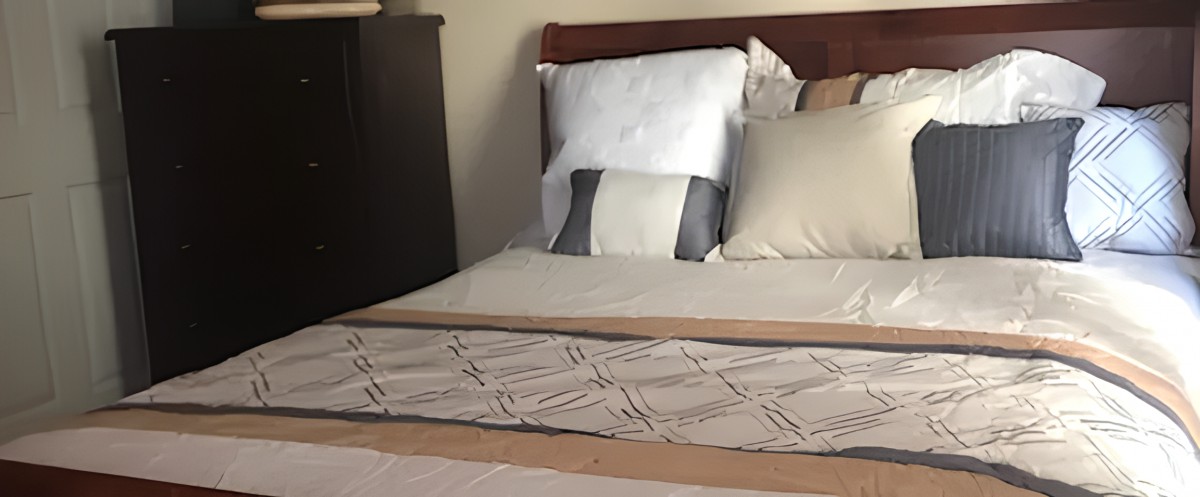 A neatly made bed with pillows and bedding in a bedroom.