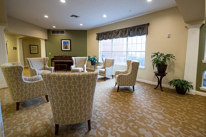 A cozy communal living room with comfortable seating and large windows.