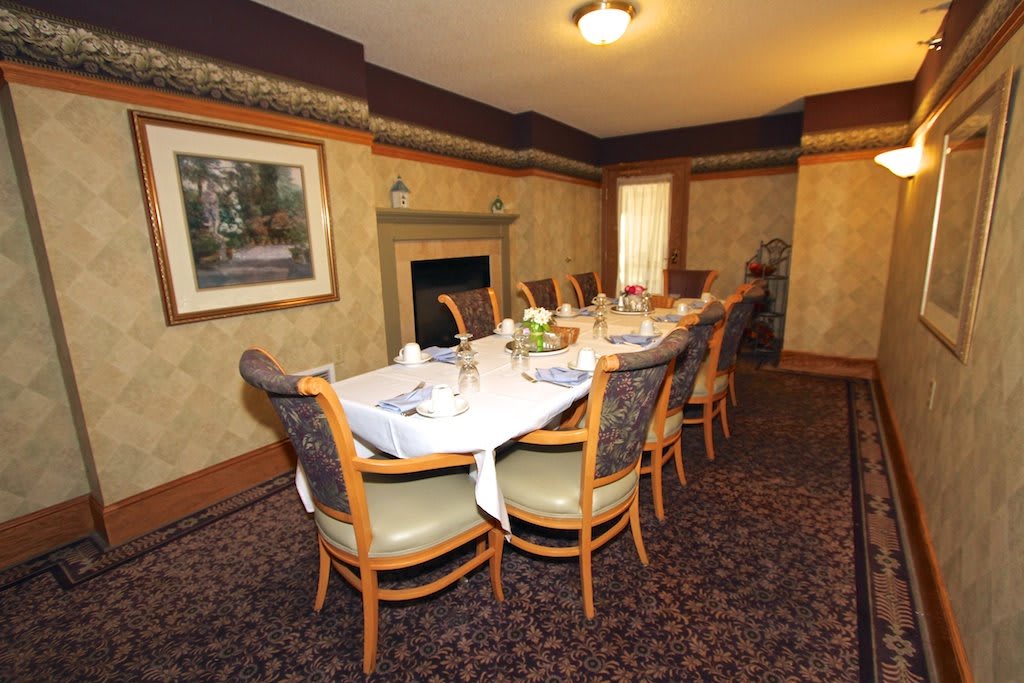 A formal dining room with a table set for guests.