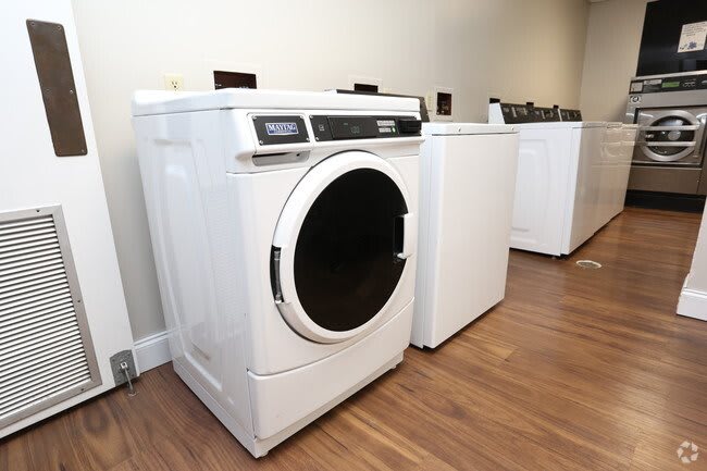 A modern laundry room featuring a front-loading washing machine and other appliances.