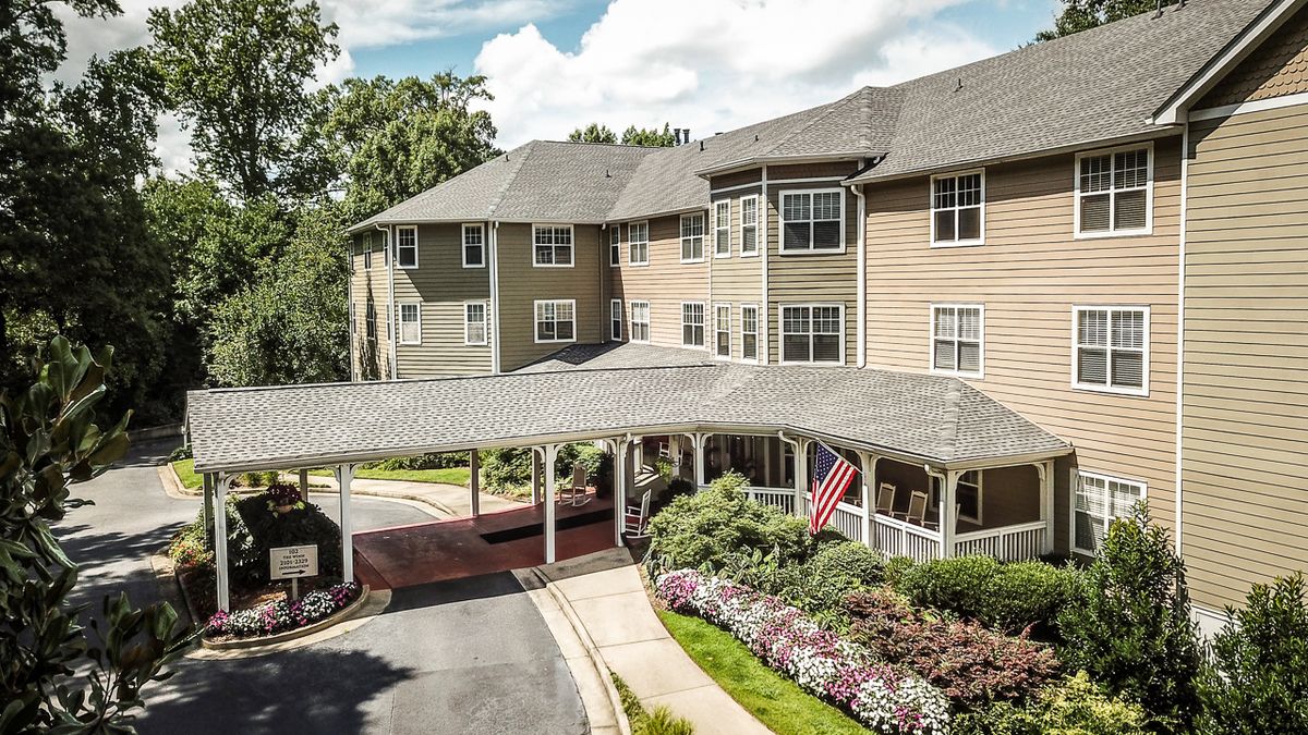 A residential building with a landscaped entrance and an American flag.