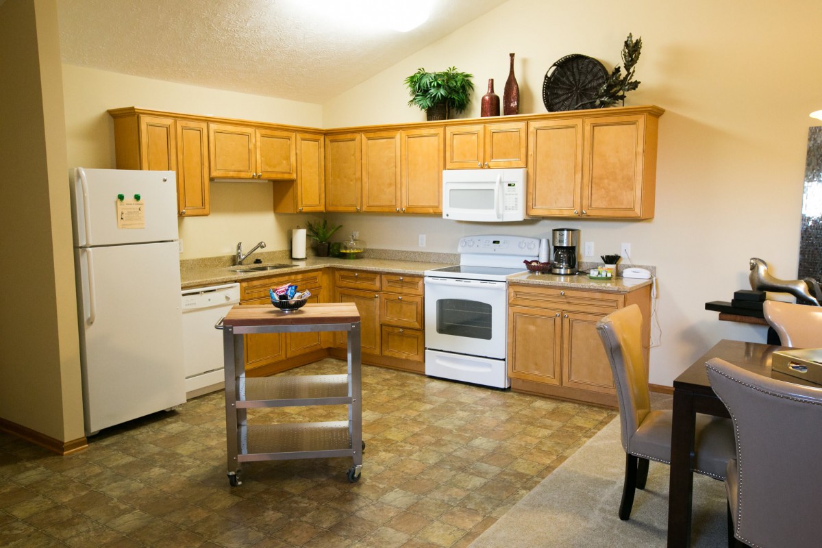 A modern kitchen with wooden cabinets, complete with appliances and decorative items.