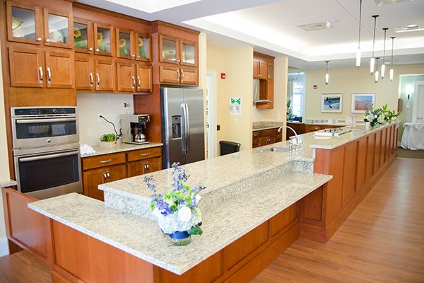 A modern kitchen with wood cabinets, granite countertops, and stainless steel appliances.