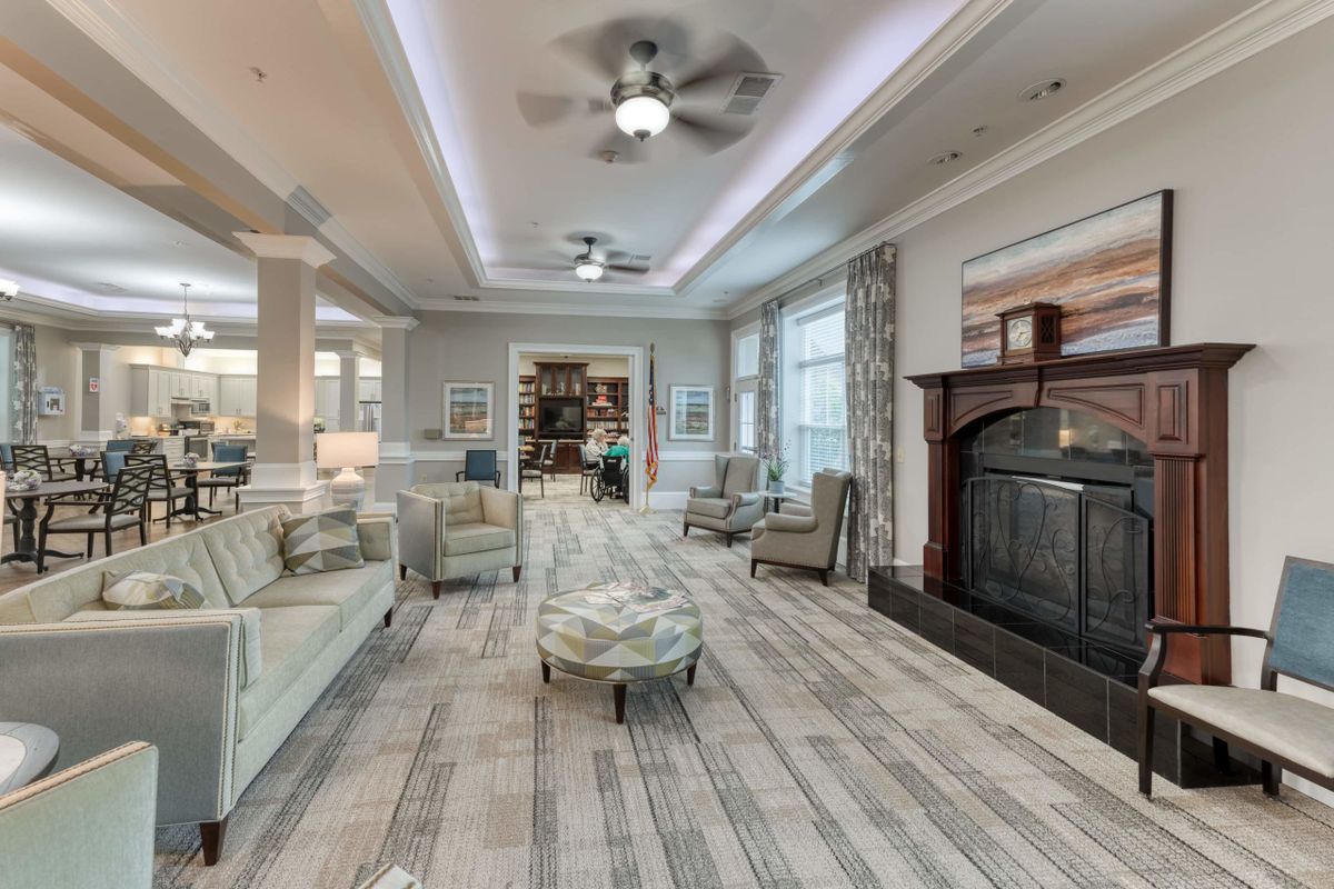 A spacious and elegantly designed living room featuring a fireplace, comfortable seating, and ample natural light.