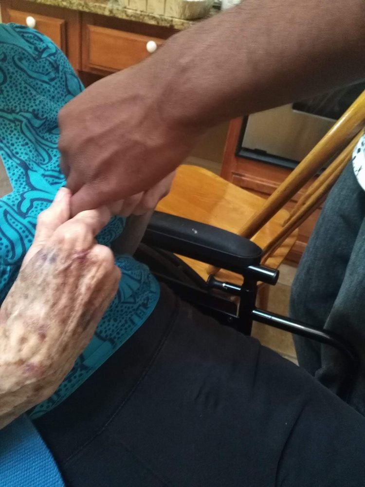 An elderly person receiving assistance from a caregiver.