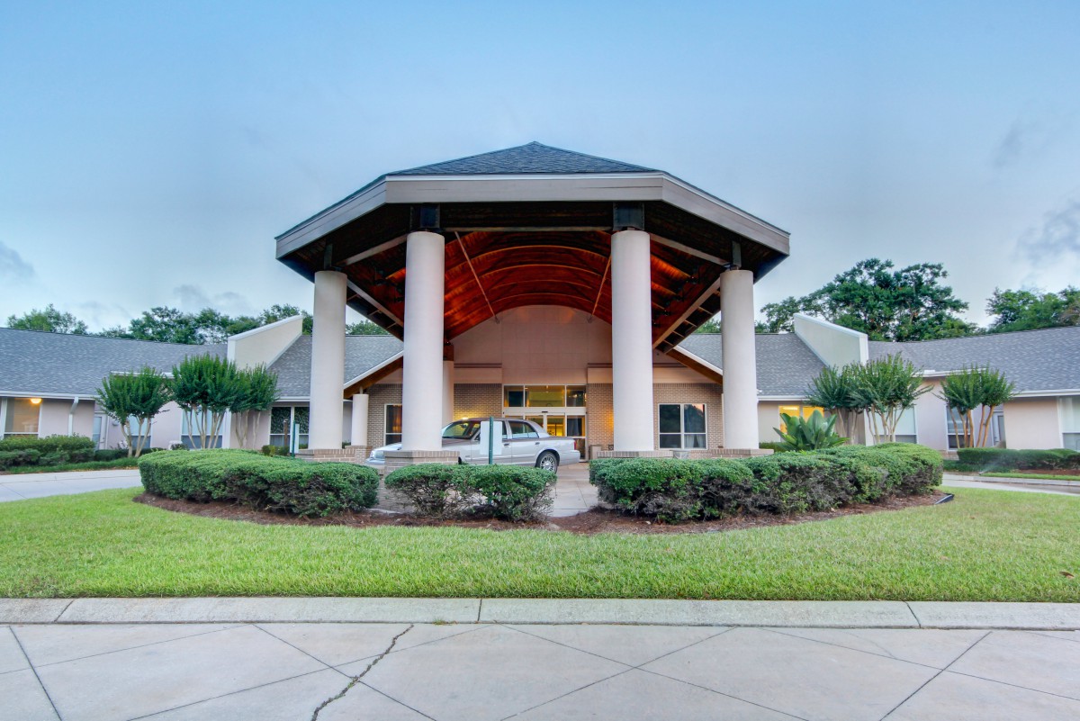 A grand building entrance with large columns and a circular driveway.