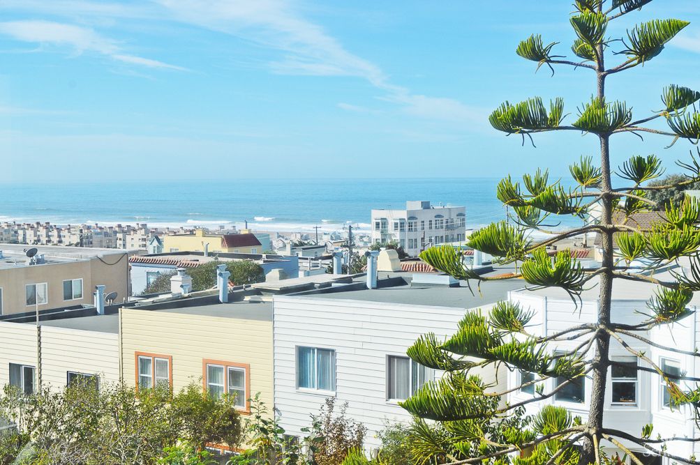 Scenic view of coastal rooftops with the ocean in the background.