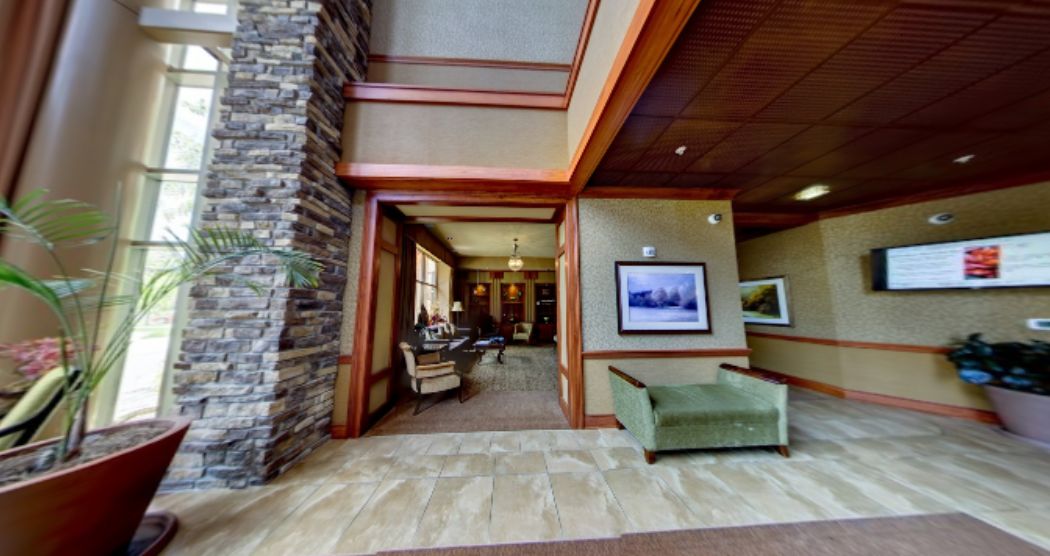 A spacious lobby area featuring a stone wall, comfortable seating, and artwork on the walls.