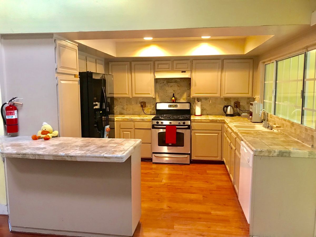 A modern kitchen with wooden floors and bright lighting.