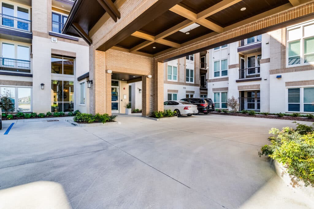 A modern apartment complex with a covered driveway entrance.