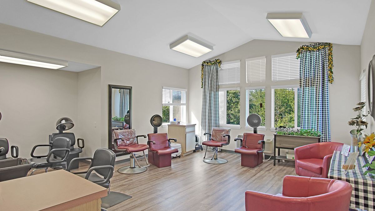 A well-lit salon with multiple hair drying stations and comfortable seating.