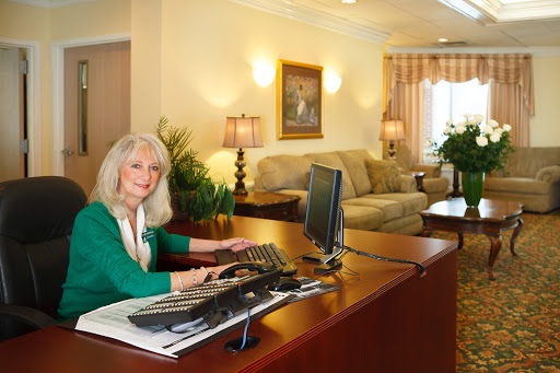 A receptionist working at a modern office desk in a well-lit lobby.