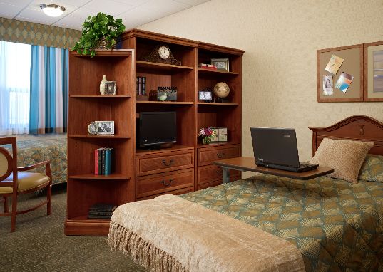 A cozy bedroom with a wooden bookshelf and desk.