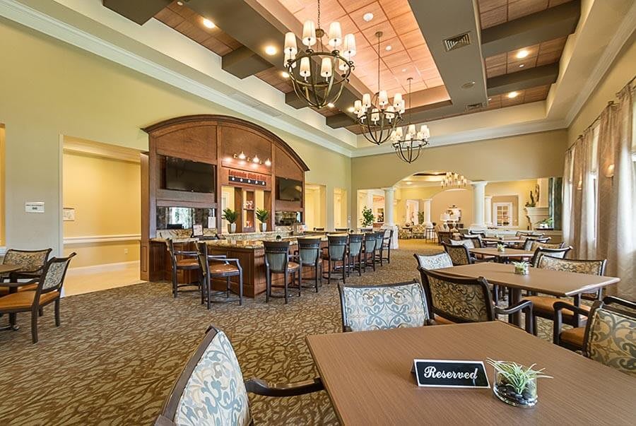 Elegant dining area with a bar and chandeliers, featuring a 'reserved' table.
