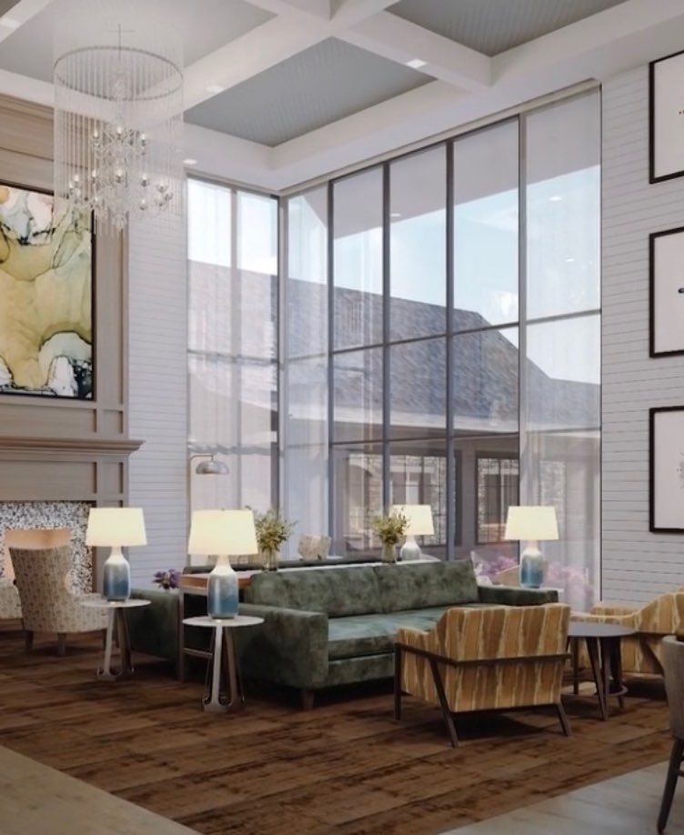 A modern living room with large windows, stylish furniture, and elegant decor.