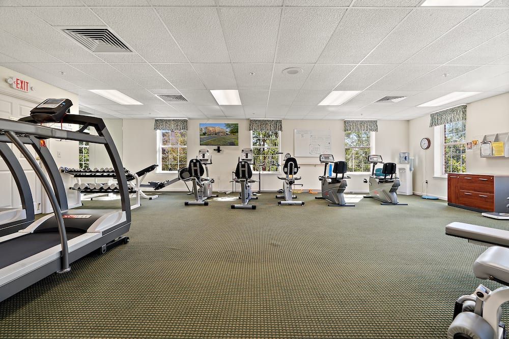 A gym with various exercise equipment including treadmills and stationary bikes.