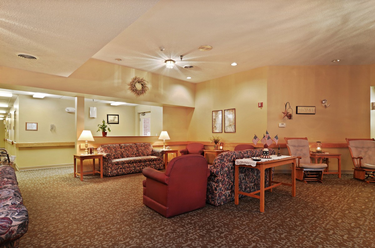 A cozy living room with sofas, armchairs, and lamps providing a warm ambiance.