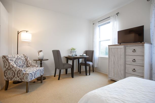 A cozy bedroom with a small dining area and elegant furnishings.