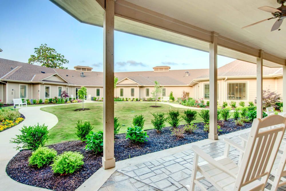 A view of a landscaped courtyard with garden space, seen from a covered patio.