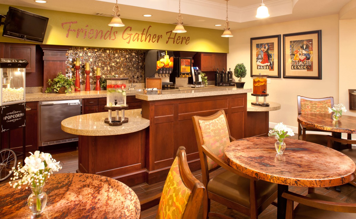 Cozy kitchen and dining area with a countertop and chairs, featuring warm decor and indoor lighting.