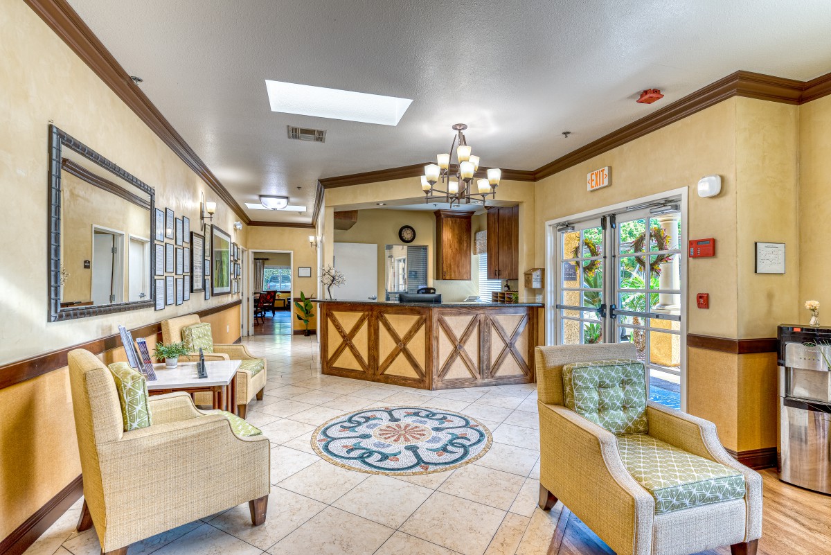 A well-lit hotel lobby with a reception desk, comfortable seating, and elegant decor.