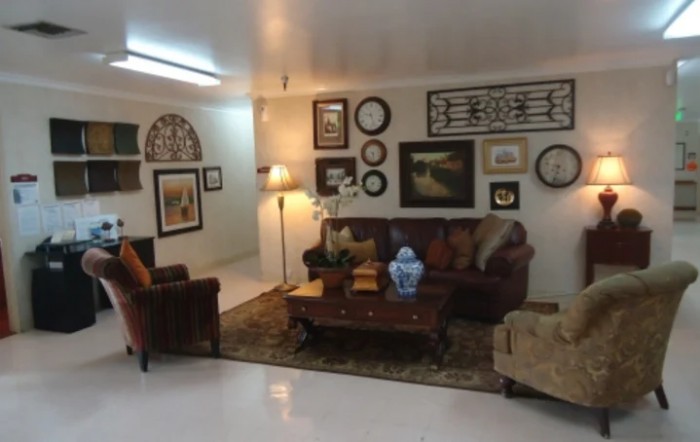 A cozy living room with art-adorned walls, comfortable seating, and warm lighting.