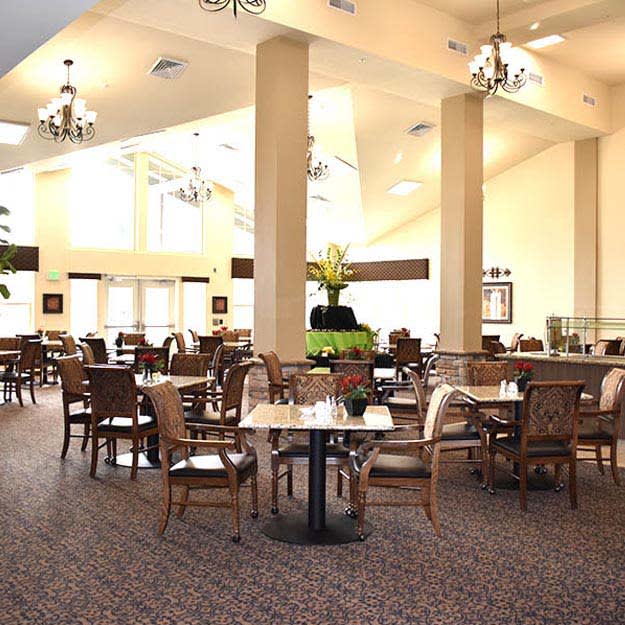 Spacious restaurant dining area with elegant chandeliers and well-arranged tables.