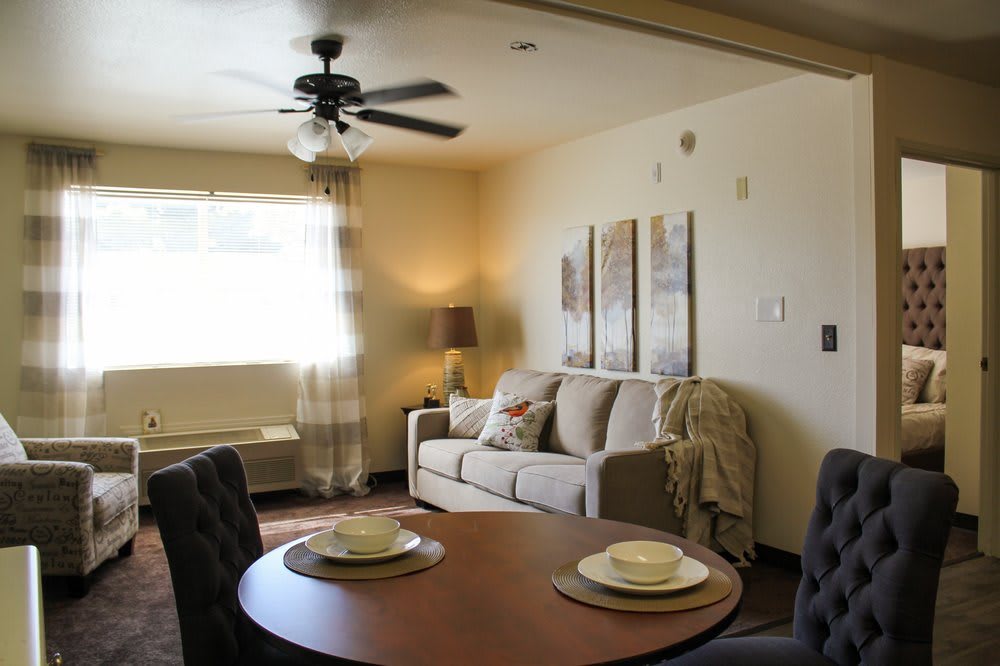 A cozy living room with a modern design, featuring a comfortable sofa and dining area.