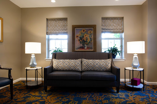 A cozy living room featuring a comfortable sofa, decorative artwork, and warm lighting.