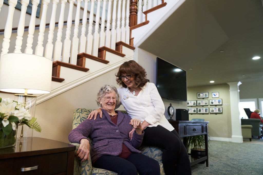 Two people sharing a joyful moment at home near a staircase.