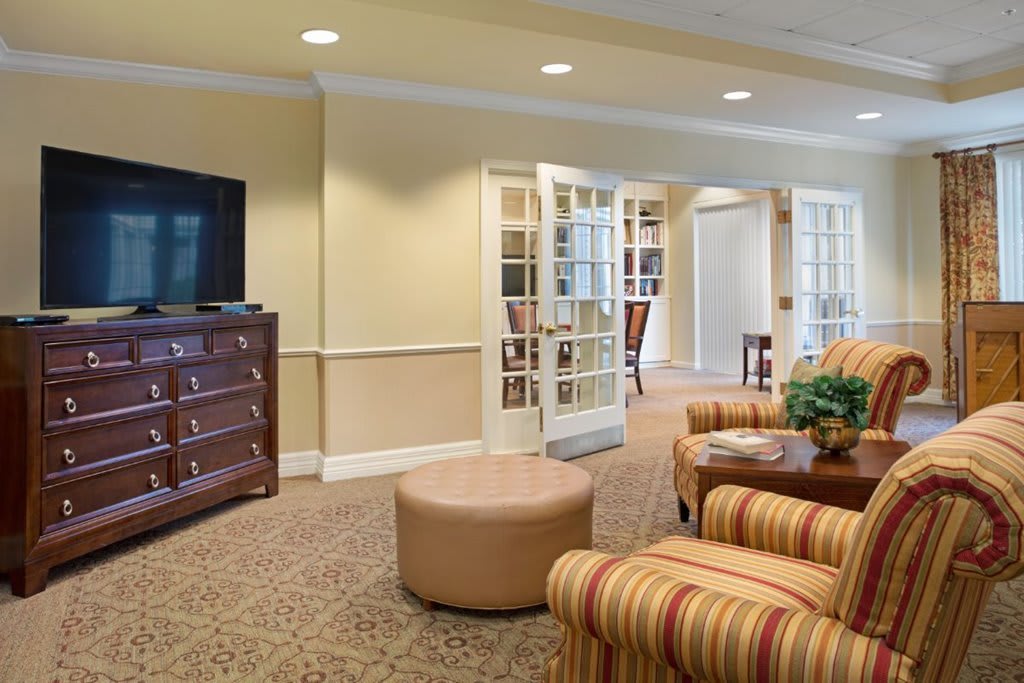 A cozy living room with a television, comfortable seating, and warm decor.