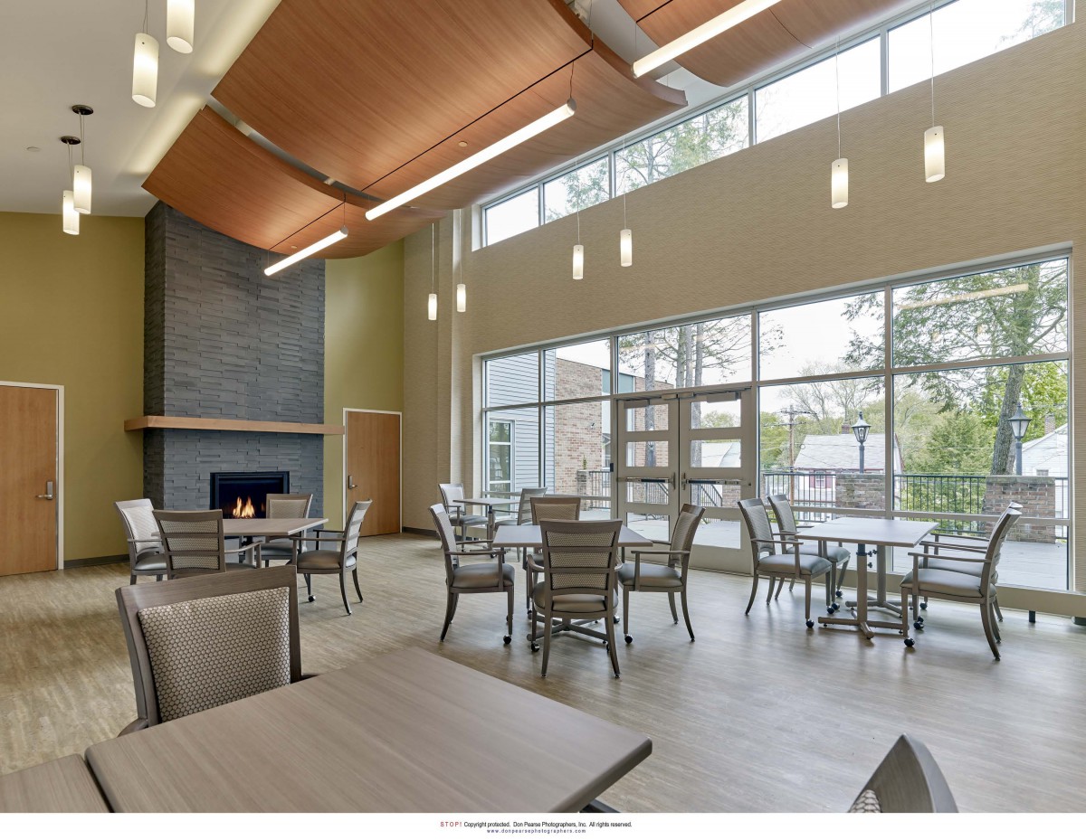 A modern dining area with large windows and a cozy fireplace.