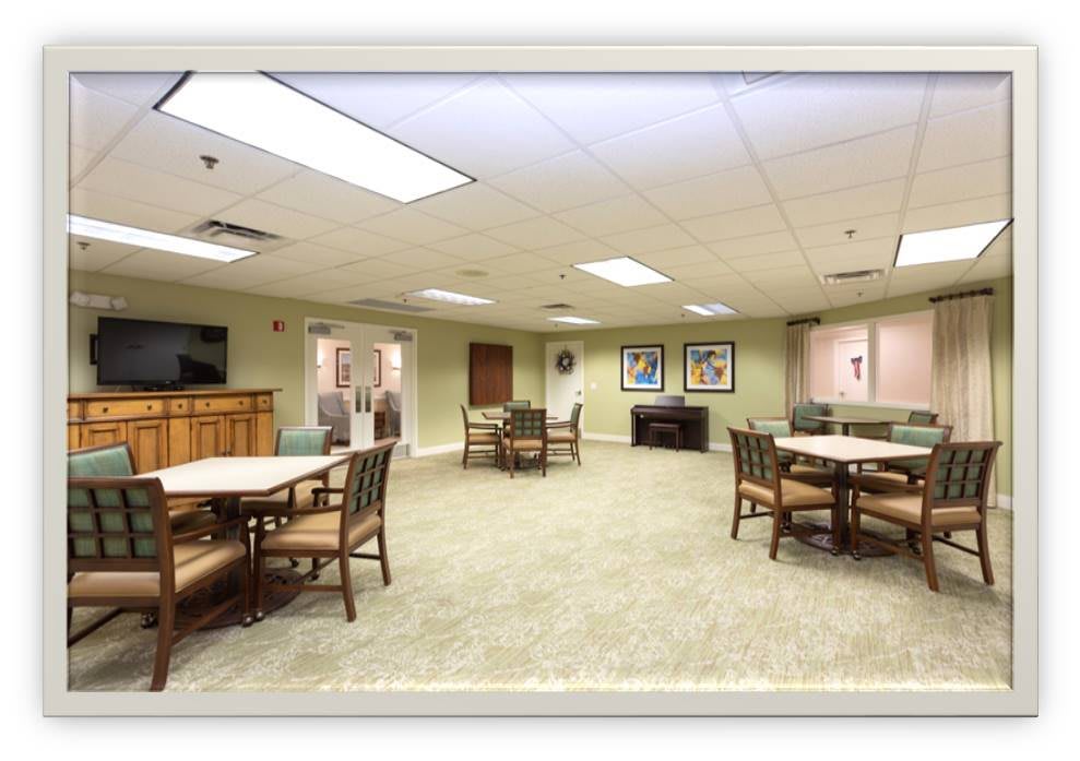 A spacious room with several tables and chairs, featuring a television and decorated walls.