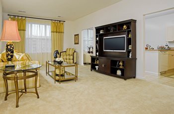 A cozy living room with a television and entertainment center, featuring comfortable seating and elegant decor.