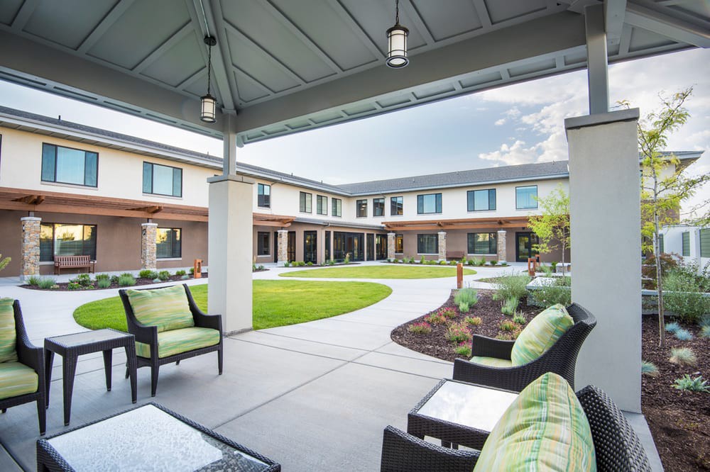 A modern courtyard featuring comfortable patio furniture and well-maintained landscaping.