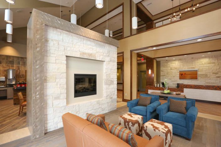 Modern living room with a stone fireplace and stylish furniture.