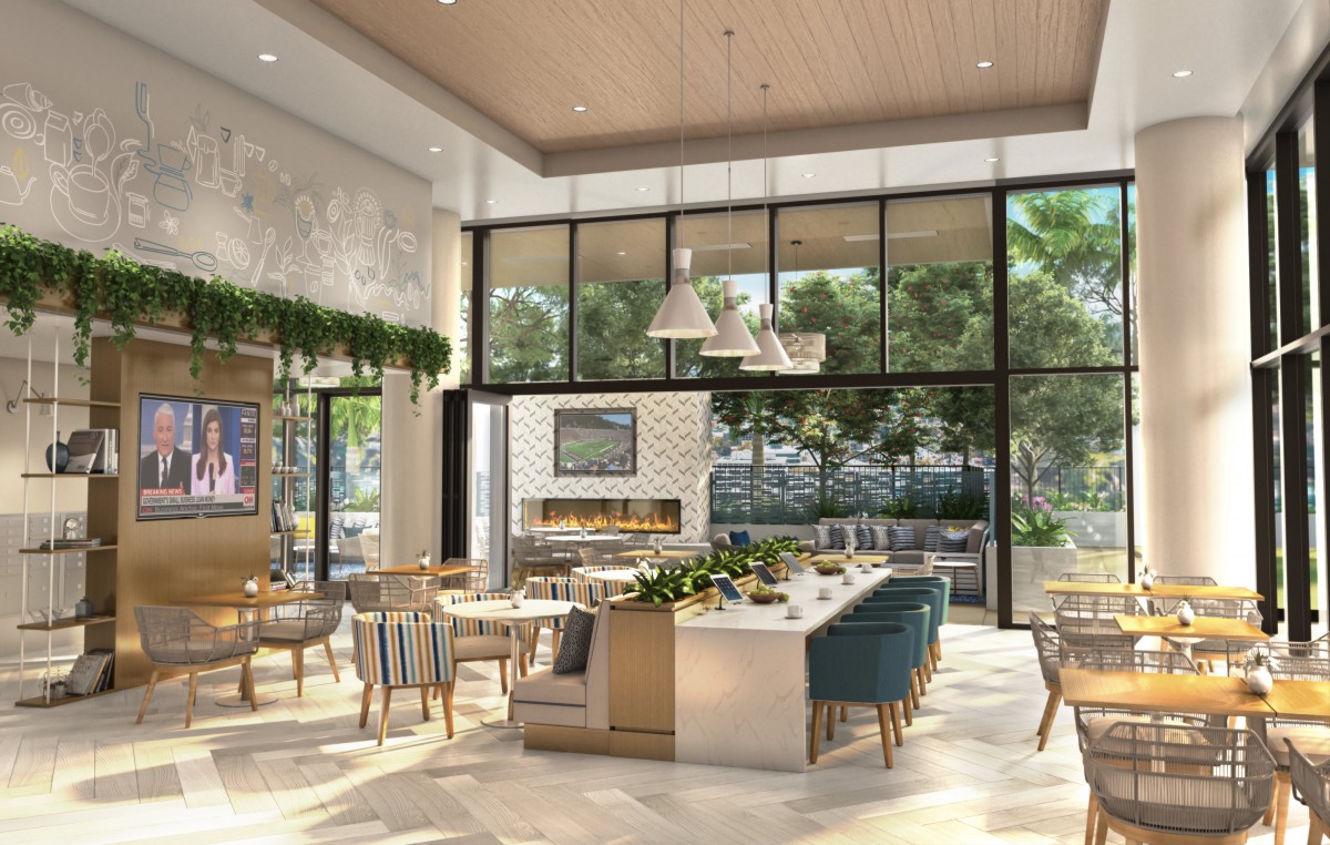 A modern and airy restaurant interior featuring wooden furniture, green plants, and large windows allowing natural light.